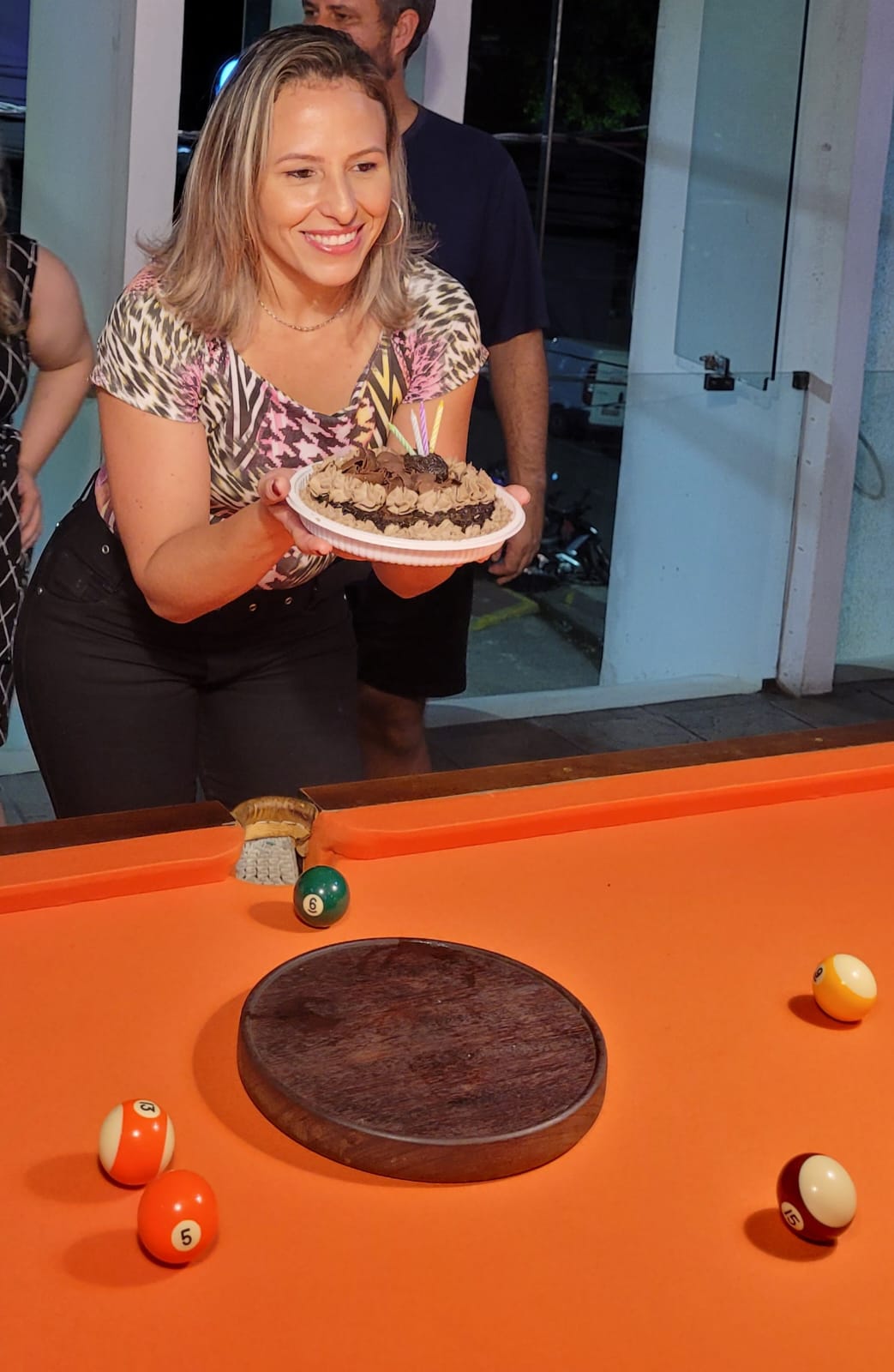 Aniversariante com bolo de chocolate na mesa de sinuca do Bola Sete Snooker Bar em São Caetano do Sul
