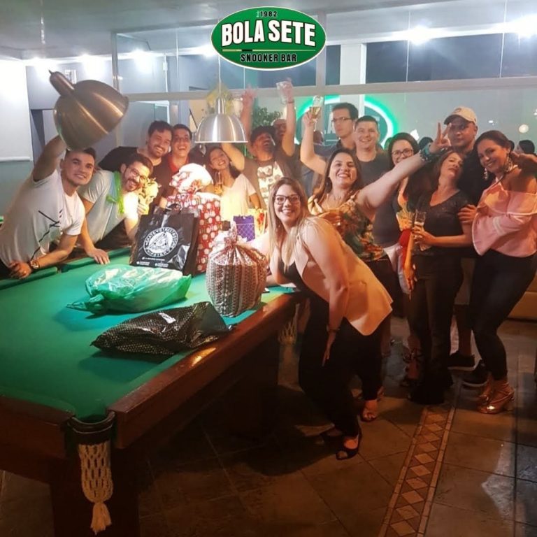 Amigos brindando e presentes sobre a mesa de sinuca em festa de aniversário no Bola Sete, São Caetano do Sul